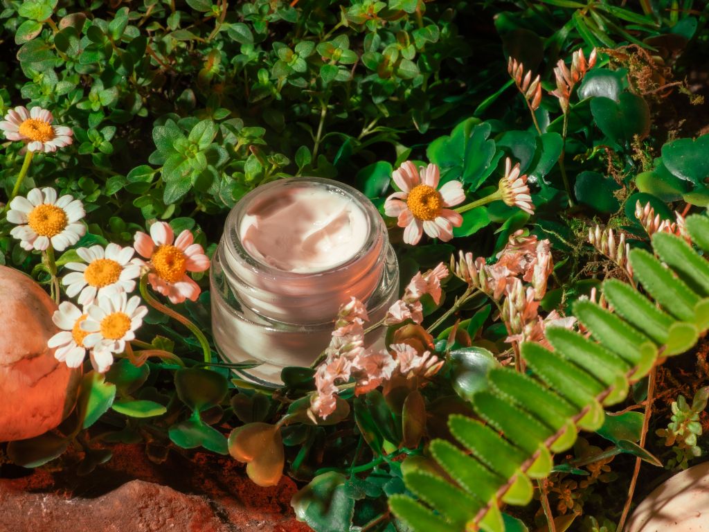 foto frasco de crema entre plantas