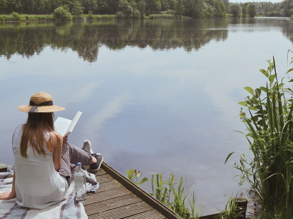 persona leyendo en un lago